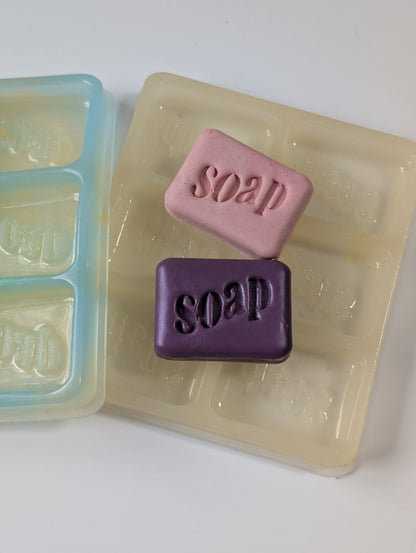 Two bars of soap with 'soap' text in a mold on a white background
